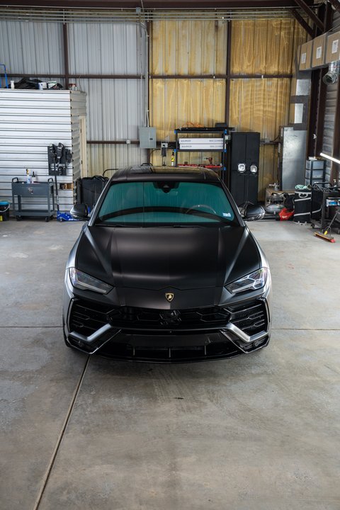 Satin black Lamborghini Urus front three-quarter after detailing
