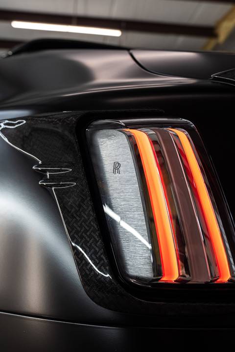 Gloss carbon fibre and taillight detail against satin paint